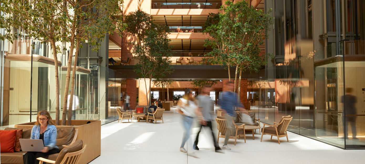 Apple-ansatte møtes, går gjennom og jobber ved forskjellige bord i det solfylte atriet på grunnplan i Battersea.