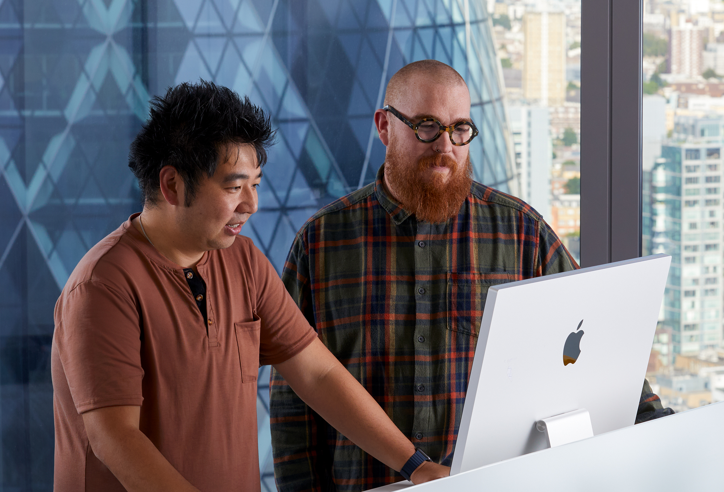 To Apple-kollegaer samarbeider på en iMac.