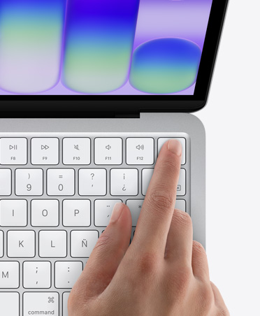 MacBook Neo, color plata, el dedo de una persona toca el sensor de Touch ID en la esquina superior derecha del teclado
