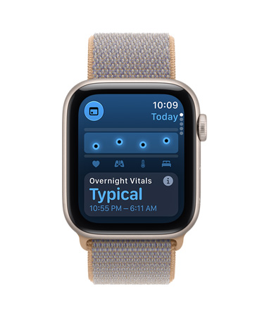 Apple Watch SE 3 csillagfényszínű alumíniumtokkal, a kijelzőn az alvási vitális jelek, Digital Crown forgatógomb a tok jobb oldalán, halvány farmerkék (világos kékesszürke) sportpánt