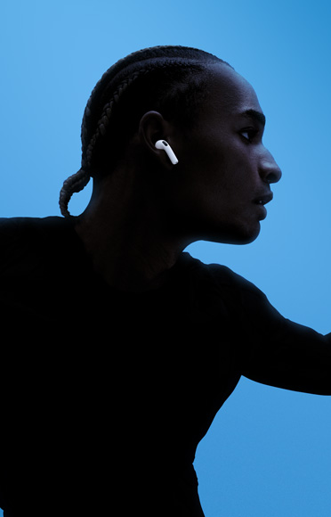 Ένα άτομο που φοράει AirPods 4.