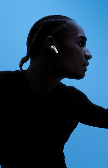 บุคคลหนึ่งใส่ AirPods 5, กางแขนออก, พื้นหลังสีสันสวยงาม