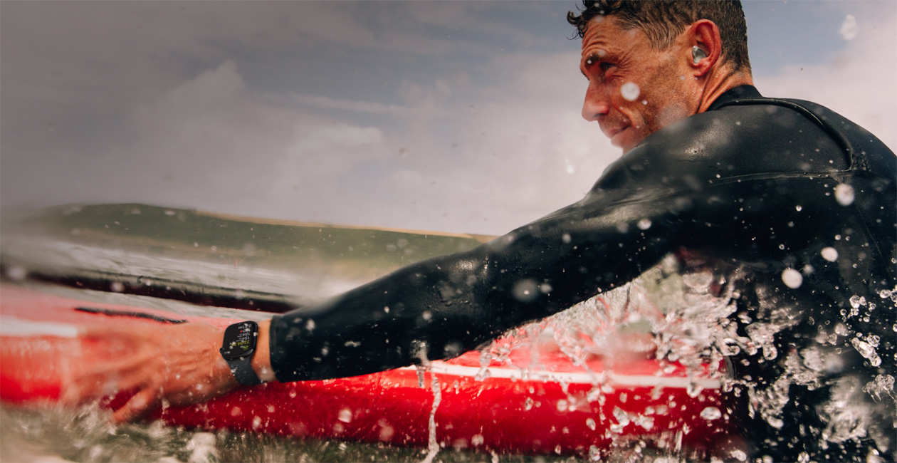 Un uomo che fa surf con un Apple Watch al polso.