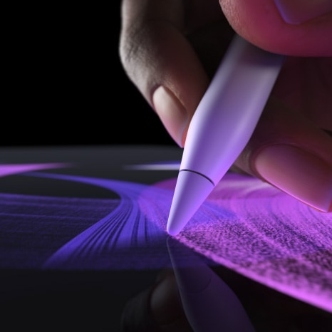 Žmogus, naudodamas „Apple Pencil Pro“ programoje „Procreate“, teptuku piešia ryškias linijas