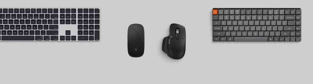 Κάτοψη ασημί Mac mini σε διαμόρφωση γραφείου με οθόνη, ασύρματα πληκτρολόγια, ασύρματα ποντίκια, χειριστήριο παιχνιδιών και AirPods Max