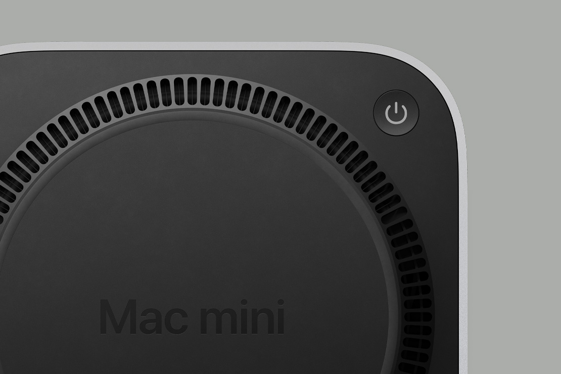 Κάτω μέρος ενός μαύρου Mac mini, με κουμπί λειτουργίας και κυκλική αρχιτεκτονική εξαερισμού που μοιάζει με ανεμιστήρα