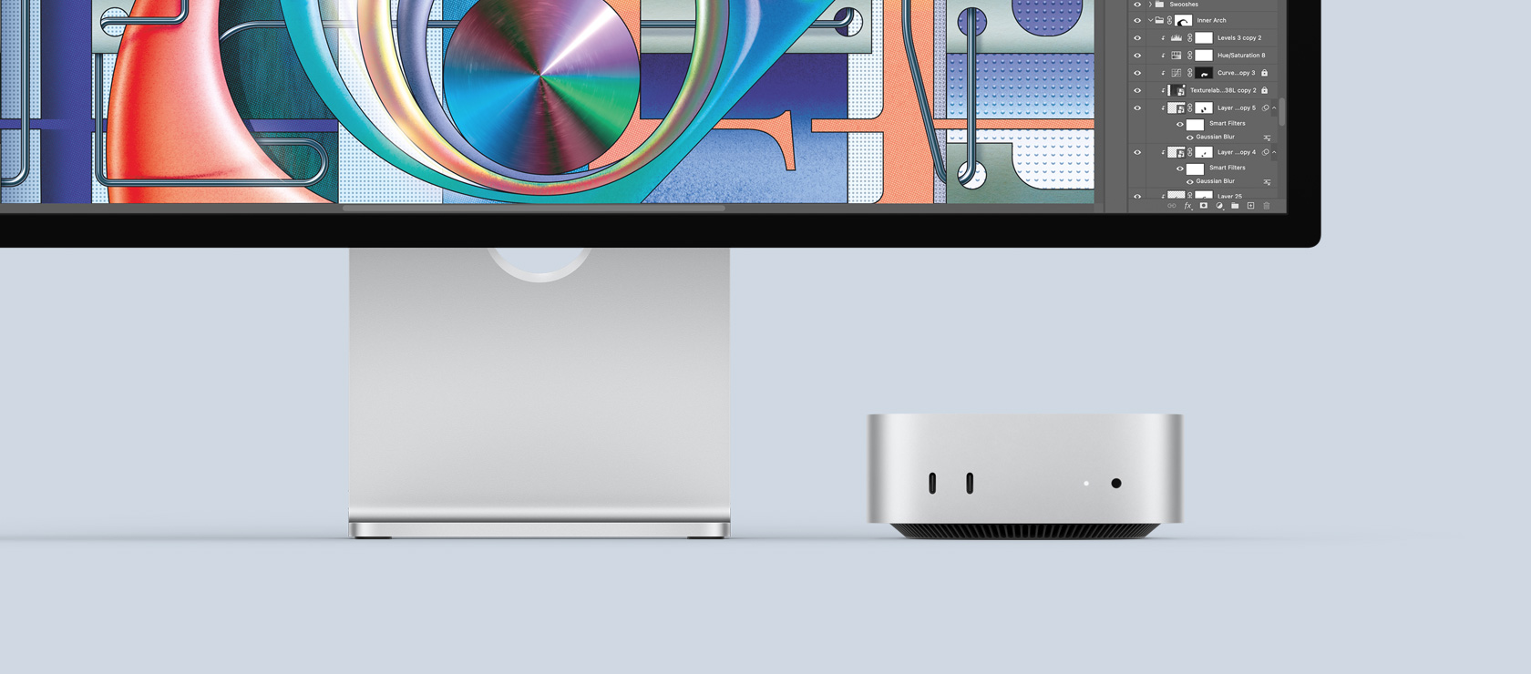 Μπροστινή όψη ασημί Mac mini που δείχνει μπροστινές θύρες και ενδεικτική λυχνία ενώ βρίσκεται τοποθετημένο κάτω από μία πολύχρωμη Mac οθόνη