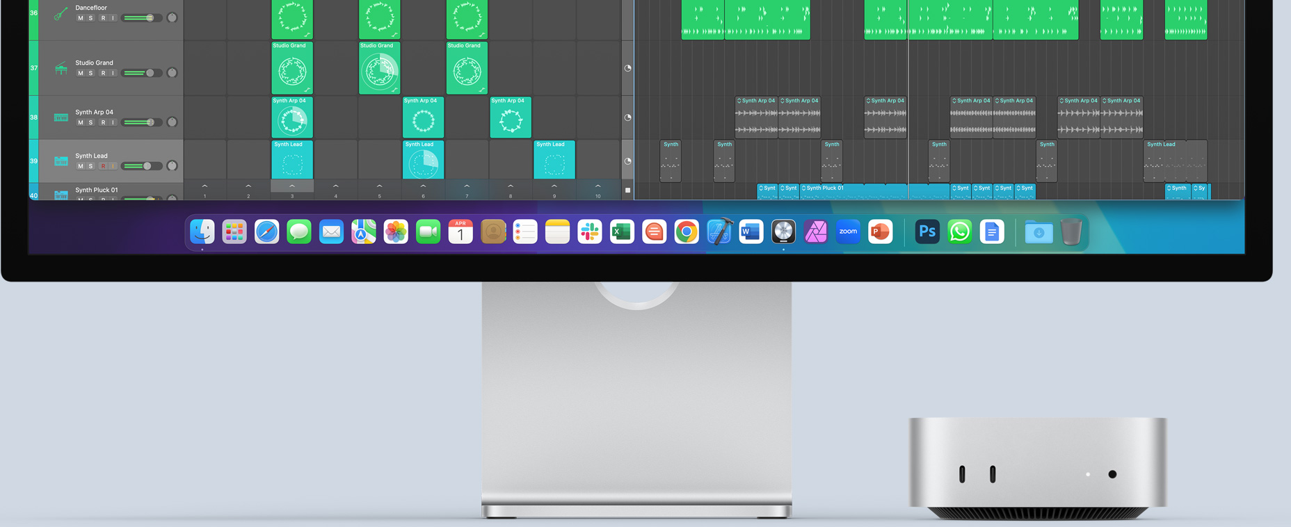 Μπροστινή όψη ενός ασημί Mac mini που δείχνει μπροστινές θύρες και λυχνία ένδειξης, ενώ βρίσκεται τοποθετημένο κάτω από μια πολύχρωμη οθόνη Mac που δείχνει τα εικονίδια των apps στο Dock